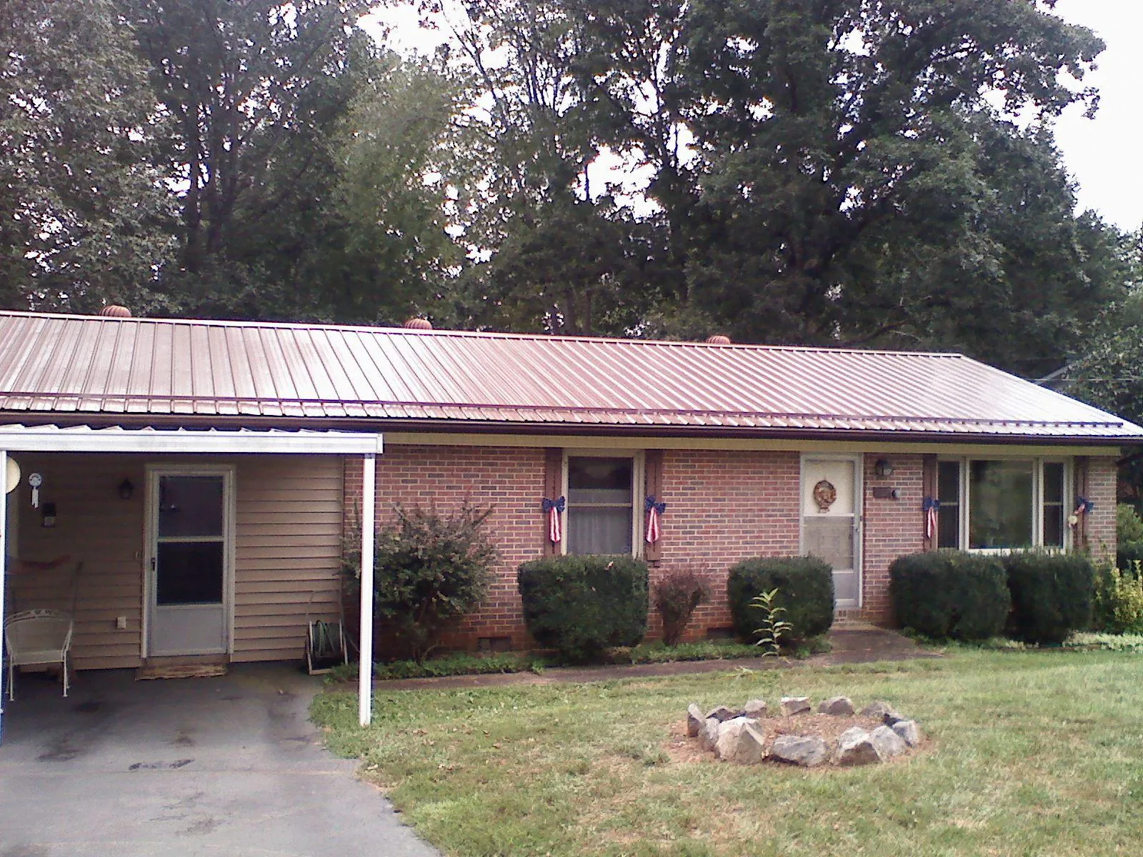 Bronze metal roof and carport on a brick ranch home — Roof Repair work by our crew in Brent